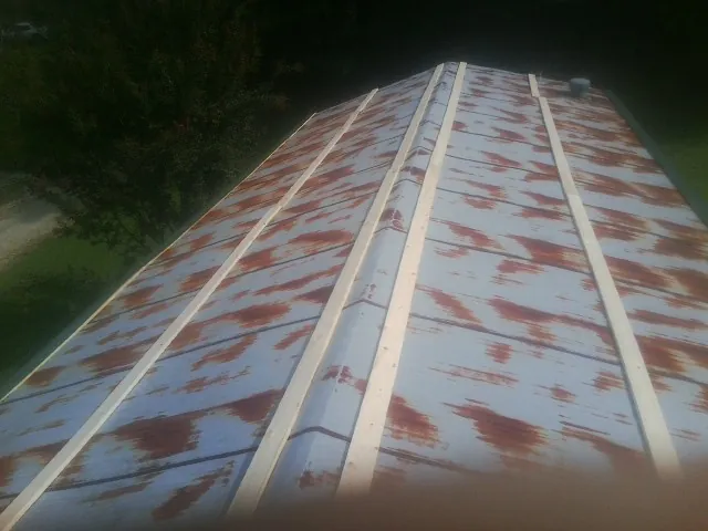 Rusted metal roof panels with new wood purlins before replacement — Storm Damage Roof Repair in Holland by Roofing Brothers