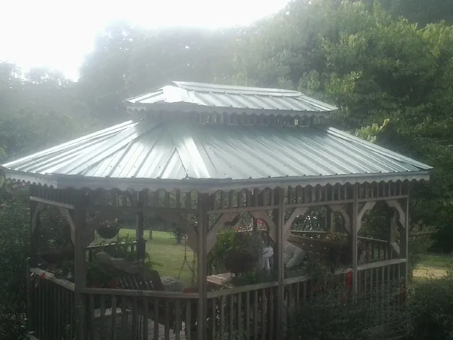 Two tier green metal roof on a garden gazebo in Holland